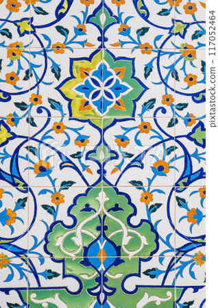 ceramic tile with traditional Uzbek floral ornament with a pattern of flowers. Wall of white mosque Minor in Tashkent in Uzbekistan 117052464