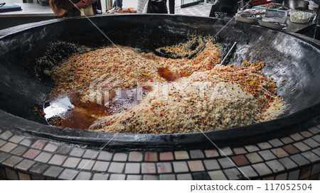 traditional national oriental Uzbek pilaf in a huge cauldron in kitchen at Tashkent Pilaf Center Besh Qozon in Uzbekistan 117052504