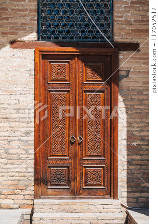Uzbek carved wooden door to Kukeldash Madrasah with traditional pattern oriental ornaments in Uzbekistan in Tashkent 117052512