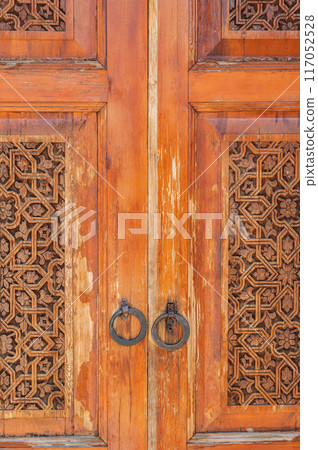 traditional Arabic Uzbek Islamic patterns arabesque ornament on an wooden carved door in Uzbekistan 117052528