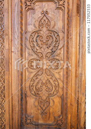 traditional oriental Uzbek patterns arabesque ornament on an ancient wooden carved door in Uzbekistan 117052533