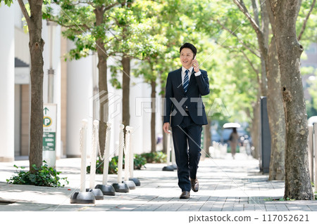 商人智慧型手機打電話步行 117052621