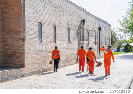 group of Uzbek male janitors in orange uniforms with shovels in summer on street in city of Tashkent in Uzbekistan group of Uzbek male janitors in orange uniforms with shovels in summer on street in city of Tashkent in Uzbekistan 117052920