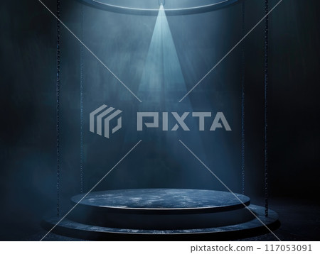 A dark room with a spotlight shining on a stage 117053091