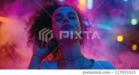 A woman with long hair is listening to music on her phone 117053323