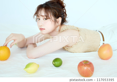 Portrait of a woman surrounded by fruit 117053395