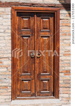 carved wooden door to islamic Kukeldash Madrasah with uzbek pattern decorated with oriental arabic ornaments in Uzbekistan in Tashkent 117053490