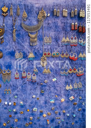 traditional oriental Uzbek earrings and women's jewelry on the counter at bazaar in Uzbekistan 117053491