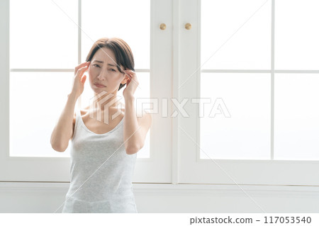 Middle-aged woman suffering from headache 117053540
