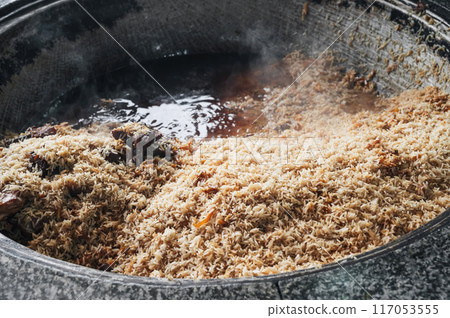 traditional oriental dish of Uzbek cuisine is rice pilaf with meat lamb in cauldron in kitchen of an restaurant in Tashkent Pilaf Center Besh Qozon in Uzbekistan 117053555