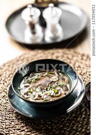 Pho Bo Vietnamese fresh rice noodle soup with beef, onions, lime, herbs and chilli decoration Pho Bo Vietnamese fresh rice noodle soup with beef, onions, lime, herbs and chilli decoration 117054052