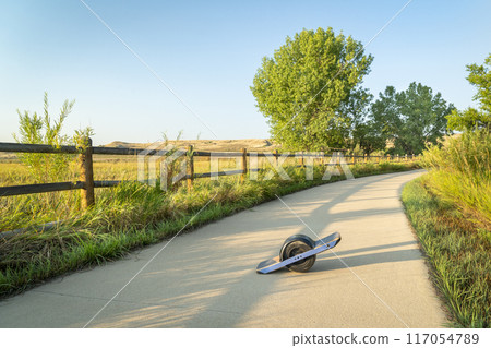 One-wheeled electric skateboard in the late summer morning on the Poudre River Trail in northern Colorado. One-wheeled electric skateboard in the late summer morning on the Poudre River Trail in northern Colorado. 117054789