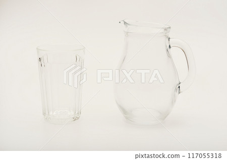 Glass jug and glass on a white background. Glassware. 117055318