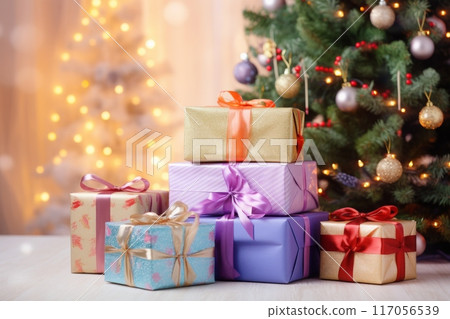 Holiday gifts arranged near a decorated tree, holiday background with copy space 117056539