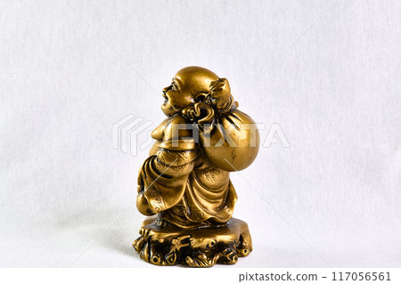 bronze figurine of Buddha walking with a bag on his shoulder, side view, souvenir 117056561