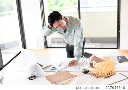 Worried Asian man in work clothes designing an architecture 117057348