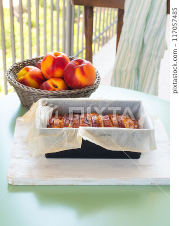 Vegan peach cake in baking mould on green table outdoors Vegan peach cake in baking mould on green table outdoors 117057485