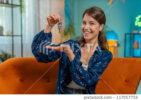 Happy woman real estate agent lifting hand showing the keys of new home buying or renting property Happy woman real estate agent lifting hand showing the keys of new home buying or renting property 117057758