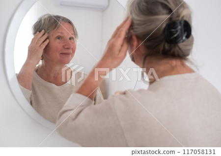 Mature Woman Looking In Mirror And Touching Wrinkles On Her Face,  117058131