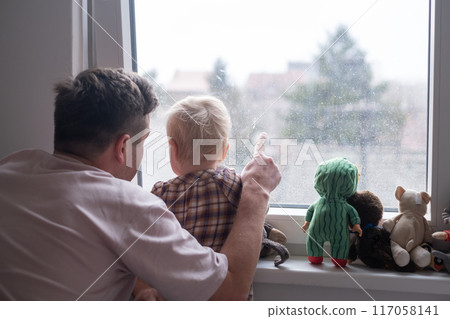 Father with toddler girl daughter looking into window  117058141