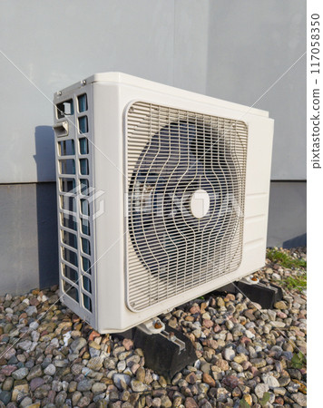 White Air Conditioning Unit on Pebbled Ground White Air Conditioning Unit on Pebbled Ground 117058350