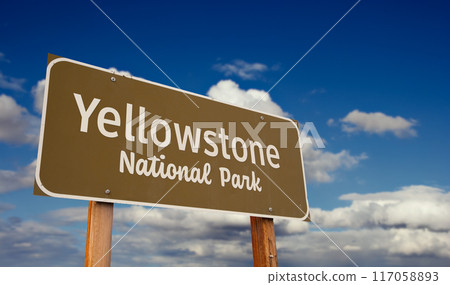 Yellowstone National Park (Wyoming, Montana, Idaho) Road Sign Against Blue Sky and Clouds. 117058893