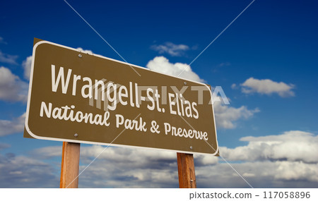 Wrangell-St. Elias National Park and Preserve (Alaska) Road Sign Against Blue Sky and Clouds. Wrangell-St. Elias National Park and Preserve (Alaska) Road Sign Against Blue Sky and Clouds. 117058896