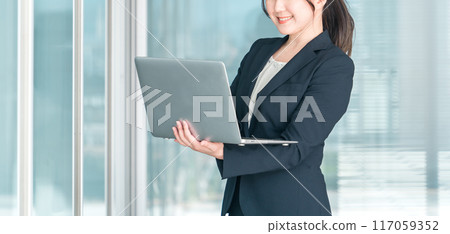 穿著西裝的亞洲女商人(企業家/女企業家)在公司/辦公室使用筆記型電腦 穿著西裝的亞洲女商人(企業家/女企業家)在公司/辦公室使用筆記型電腦 117059352