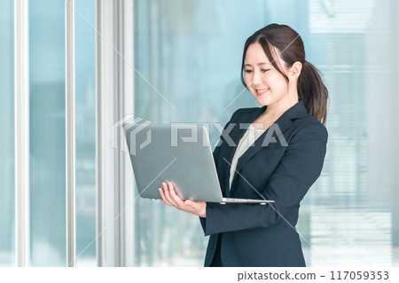 穿著西裝的亞洲女商人(企業家/女企業家)在公司/辦公室使用筆記型電腦 穿著西裝的亞洲女商人(企業家/女企業家)在公司/辦公室使用筆記型電腦 117059353