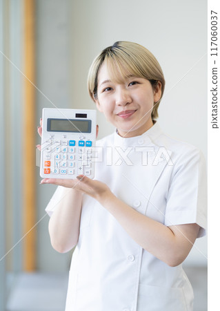 一位年輕的金髮短髮女脊椎按摩師拿著計算器（自由髮色，以自己的方式工作，工作環境） 117060037