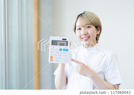 A young female chiropractor with short blonde hair holding a calculator (free hair color, work in your own way, work environment) A young female chiropractor with short blonde hair holding a calculator (free hair color, work in your own way, work environment) 117060041