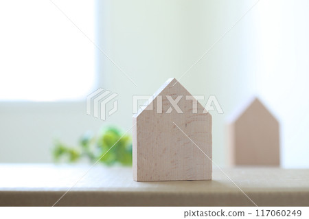 A soft, light-filled image of a home with a small model of a house placed by the window 117060249