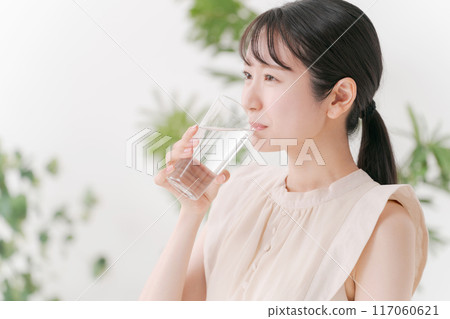 Young woman drinking a glass of water 117060621