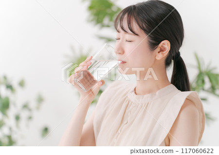 Young woman drinking a glass of water 117060622