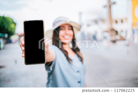 Tourist girl showing cell phone screen on the street. Travel woman showing cell phone screen on the street 117062225