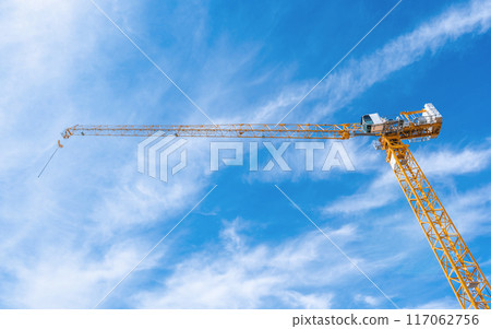 Tower crane working in construction site and stand out from the cloudy bright blue sky Tower crane working in construction site and stand out from the cloudy bright blue sky 117062756