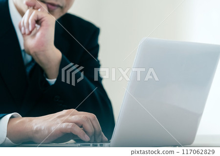 Businessman worried while looking at a computer 117062829