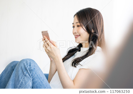 在沙發上的女人看智能手機 在沙發上的女人看智能手機 117063250
