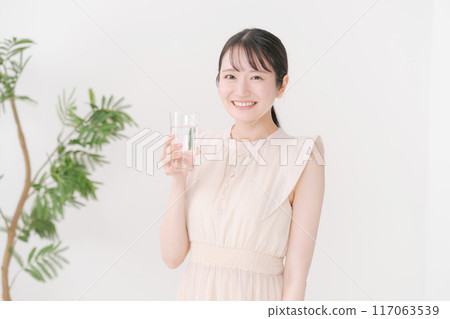 Young woman holding a glass of water 117063539
