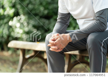 Senior man sitting on a park bench, tired Senior man sitting on a park bench, tired 117064951