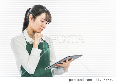在便利店/超市使用平板終端管理庫存的店員/兼職女性（擔心/擔心） 117065639