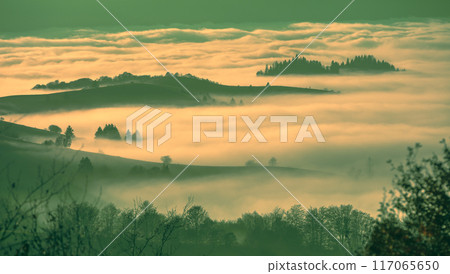 Fantastic view of the tops of the mountain ridge above the clouds Fantastic view of the tops of the mountain ridge above the clouds 117065650