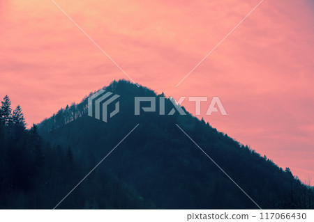 Silhouette of the mountain against a pink sunset sky 117066430