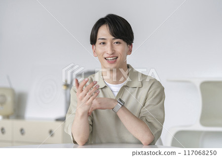 A man in his early twenties talking looking at the camera 117068250