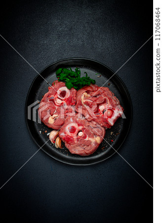 raw steak, calf's neck on the bone, fresh meat, on a black plate, top view, no people, raw steak, calf's neck on the bone, fresh meat, on a black plate, top view, no people, 117068464
