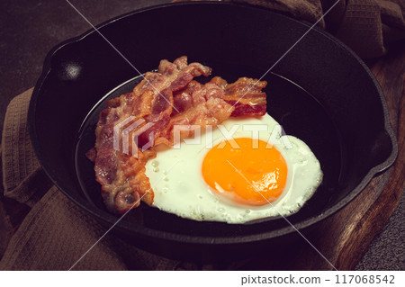 fried egg with bacon, in a cast-iron pan, breakfast, top view, close-up, homemade, no people, 117068542