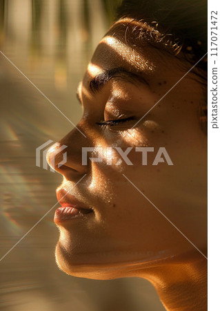 Closeup of relaxed woman's face Thai massage sunlight streaming elegant spa 117071472