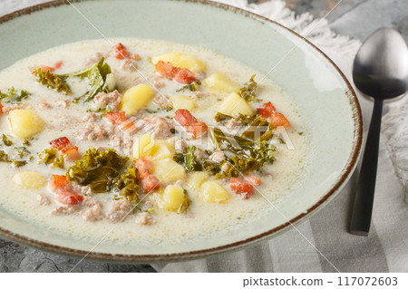 Italian traditional soup Zuppa Toscana with sausages, kale, potatoes and bacon close-up in a plate. Horizontal Italian traditional soup Zuppa Toscana with sausages, kale, potatoes and bacon close-up in a plate. Horizontal 117072603