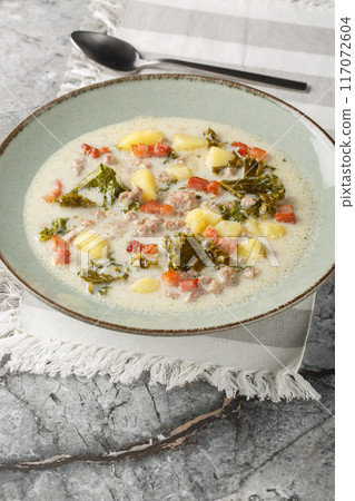 Zuppa Toscana hearty Tuscan Soup loaded with Italian sausage, kale, fried bacon and potatoes closeup on the plate. Vertical 117072604