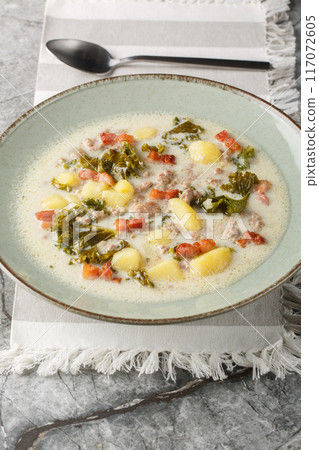 Meaty creamy zuppa toscana soup with Italian sausage, bacon and vegetables closeup on the plate. Vertical Meaty creamy zuppa toscana soup with Italian sausage, bacon and vegetables closeup on the plate. Vertical 117072605